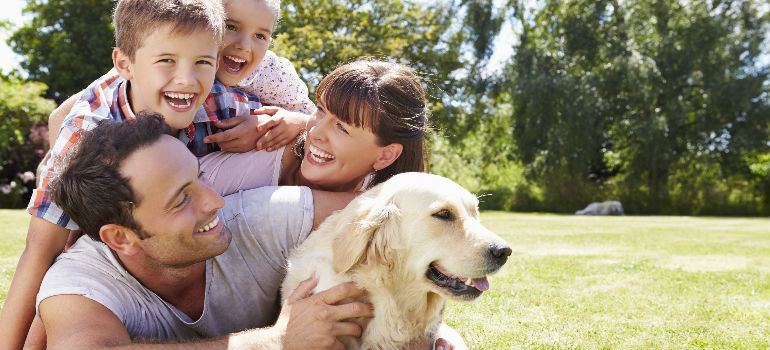 A happy family with golden retriever in the park